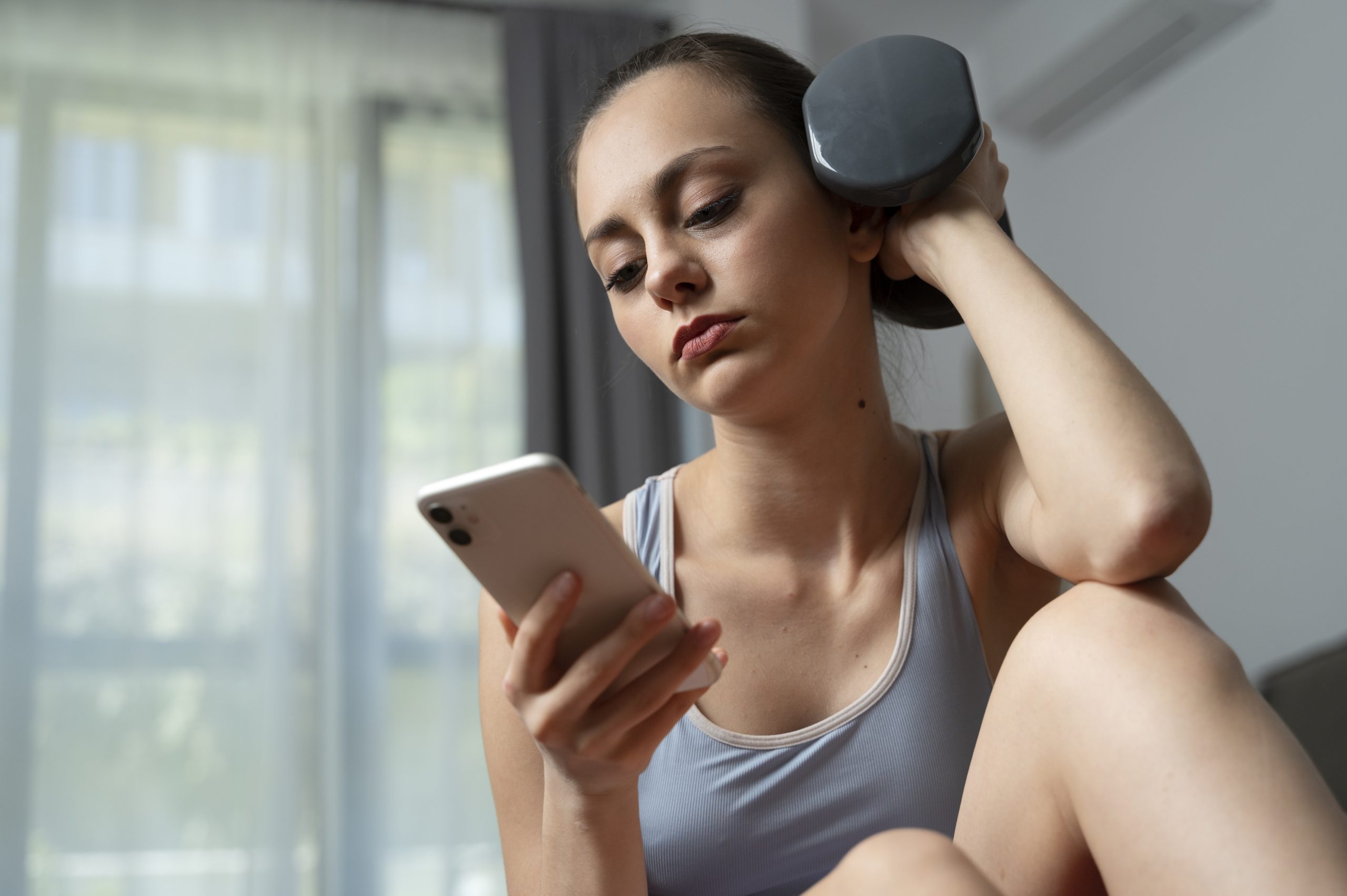 garota-de-tiro-medio-malhando-com-smartphone