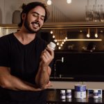 7 Sinais de que Sua Saúde Intestinal Não Está Bem (e Como Melhorar Naturalmente) Mulher sorrindo com tigela de iogurte e frutas, simbolizando saúde intestinal e bem-estar