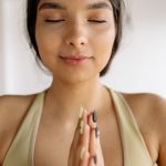 5 Estratégias Eficazes para Lidar com a Ansiedade no Dia a Dia Mulher praticando meditação em um jardim, transmitindo serenidade e calma para lidar com a ansiedade.